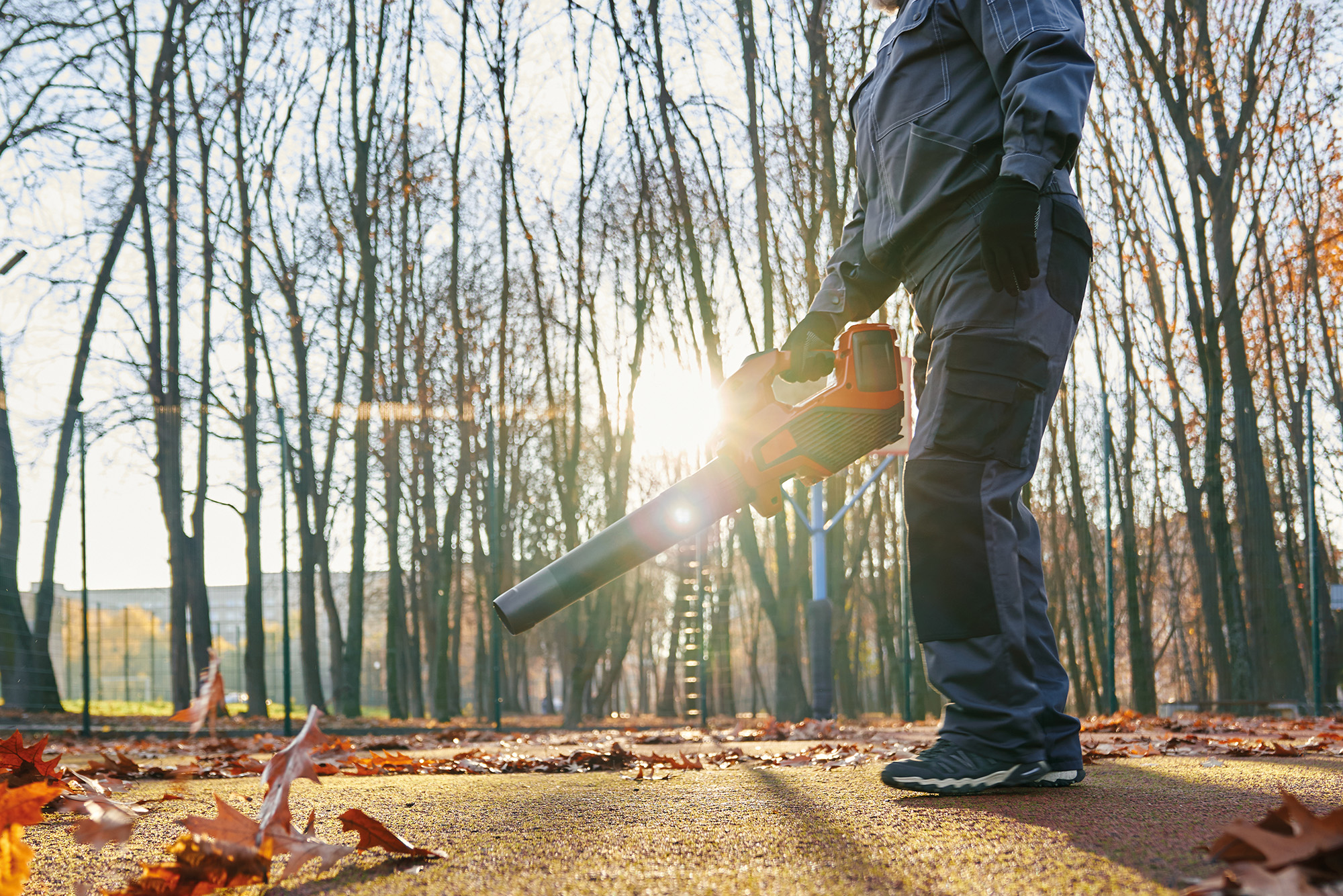 Mann mit Laubsauger im Herbst